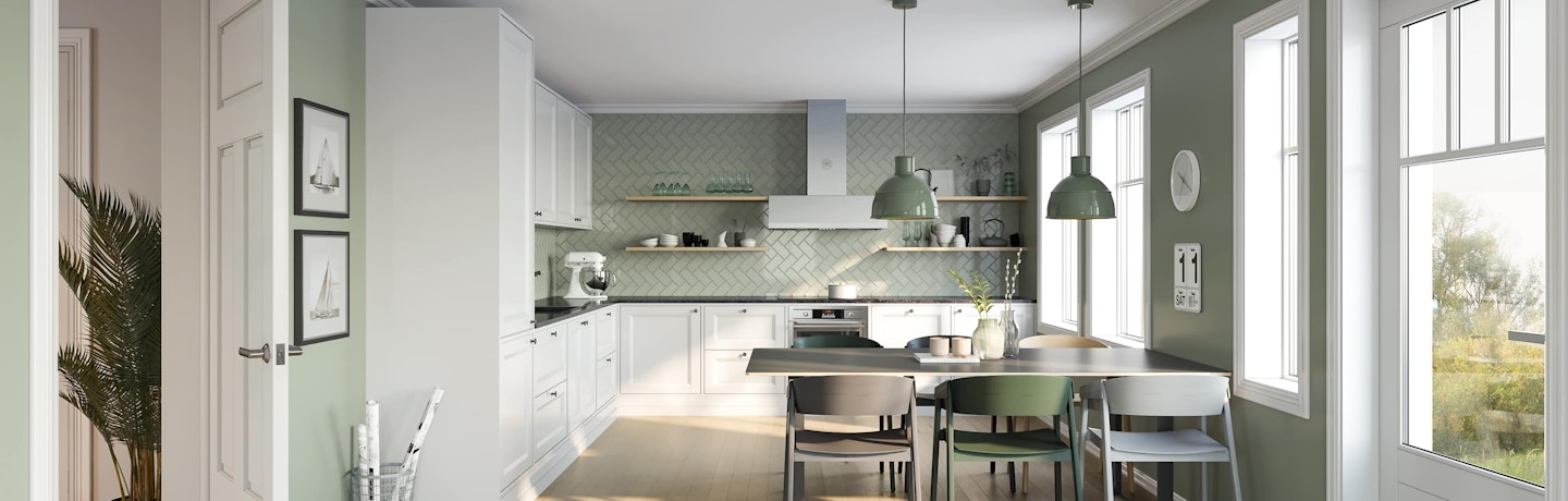 Klassisk hvitt L-kjøkken med sort benkeplate, lys grønne vegger og grønne fliser over kjøkkenbenk i fiskebenmønster. Husmodell Aprilvår.