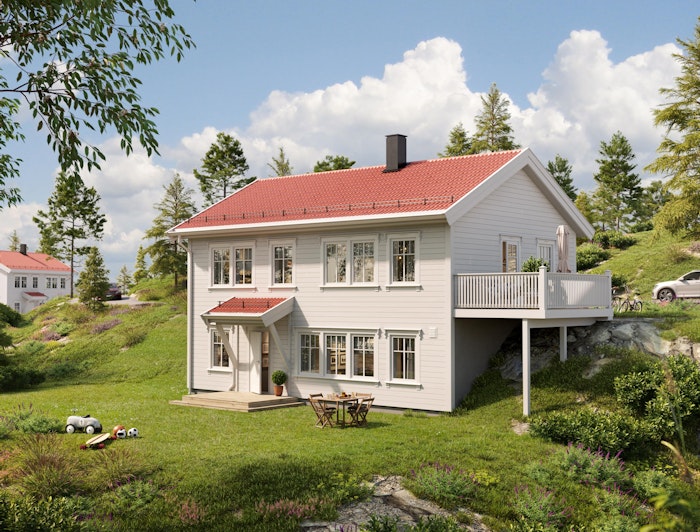 Klassisk hvitmalt hus med rødt tak på skrå tomt. Huset Marsmorgen har stor terrasse med utgang fra hovedplan. Grønn og frodig hage i sommervær.