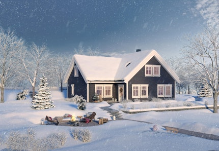 Ferdighuset Desemberfryd, et sortmalt vinkelhus på to plan med hvite detaljer. Vinter og snø, og uteplass med ild i bålpanne gir julestemning.