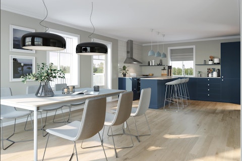 Kjøkken med spisebord i lyst grått og hvit med kjøkkeninnredning i mørk blått med hvit benkeplate. Klassisk husmodell Februarsaga.