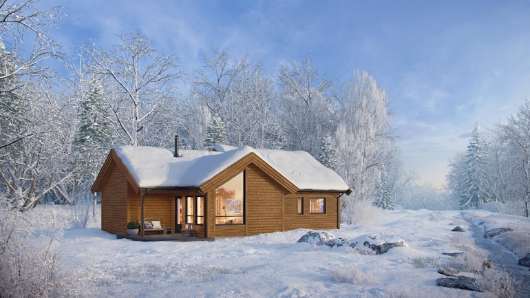 Brunbeiset hytte med mange hjørner i vinterlandskap. Overbygd veranda med plass til en liten sittegruppe.