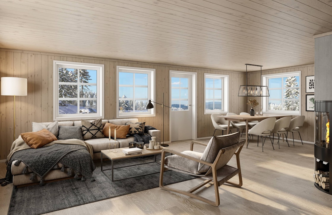 Her ser vi stuen og spisestuen i fritidsboligen RO1. Utenfor vinduene er det snødekt og lyst.