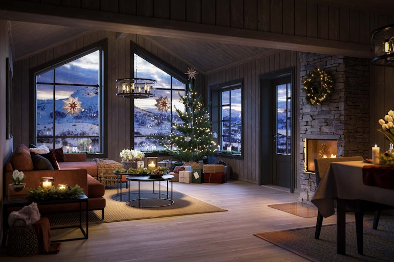 Hytta Bukkespranget er pyntet til julefeiring med juletre, adventstjerner i vinduene og juledekket spisebord.