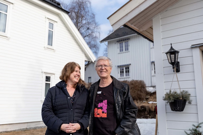 Anne og Olav står på sin nye tomt, i sin gamle hage. De valgte å skille ut en tomt fra eiendommen sin, og så bygge nytt hus på egen tomt.