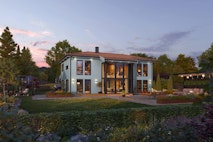 Moderne villa med valmet tak og store vinduer i front.