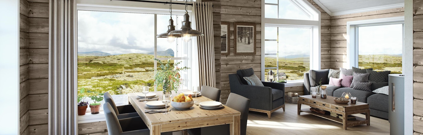 Det er hyggelig å sitte her ved spisebordet i hytta Gråhø. Det er høyt under taket og store vinduer som gir en nær kontakt med omgivelsene utenfor.