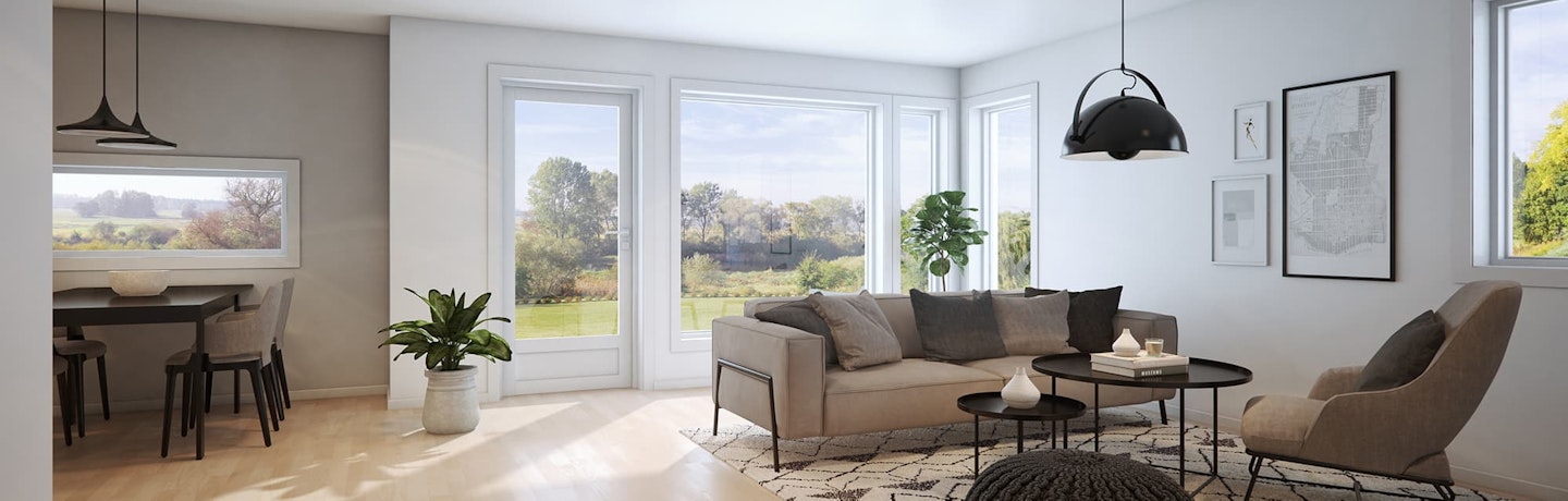 Hvitmalt stue fra tomannsboligen Tellus. Med beige sofa, sorte og grå interiørelementer og sort spisestue. Utsikt til hage og uteområde.