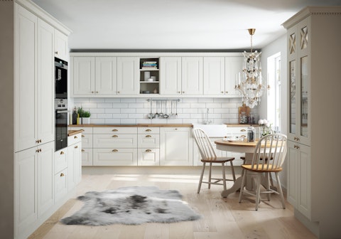 Kjøkken i husmodell Raumarheim her i klassisk stil med hvit profilert kjøkkeninnredning og benkeplate i tre.