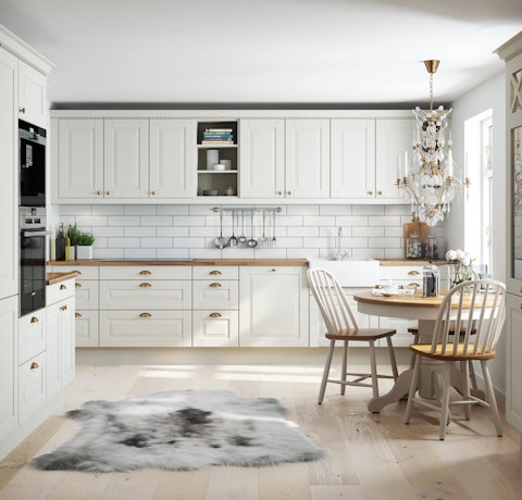 Kjøkken i husmodell Raumarheim her i klassisk stil med hvit profilert kjøkkeninnredning og benkeplate i tre.