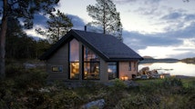 Skramstad er en av våre små hytter på under 50 kvm. Her er hytta vist frem i kvelddstemning, plassert på en tomt nede ved vannet.