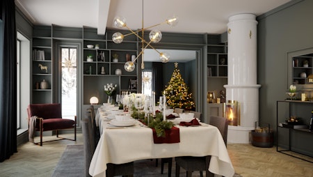 Julepyntet spisebord i en herskapelig spisestue malt i mørk grått med en hvit kakkelovn og stort juletreet som skinner i bakgrunnen. Julestemning i herskapelige husmodell Constantine.